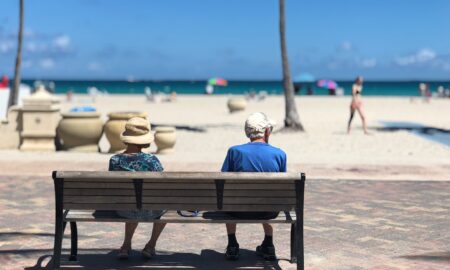 man and woman sitting on brown wooden bench